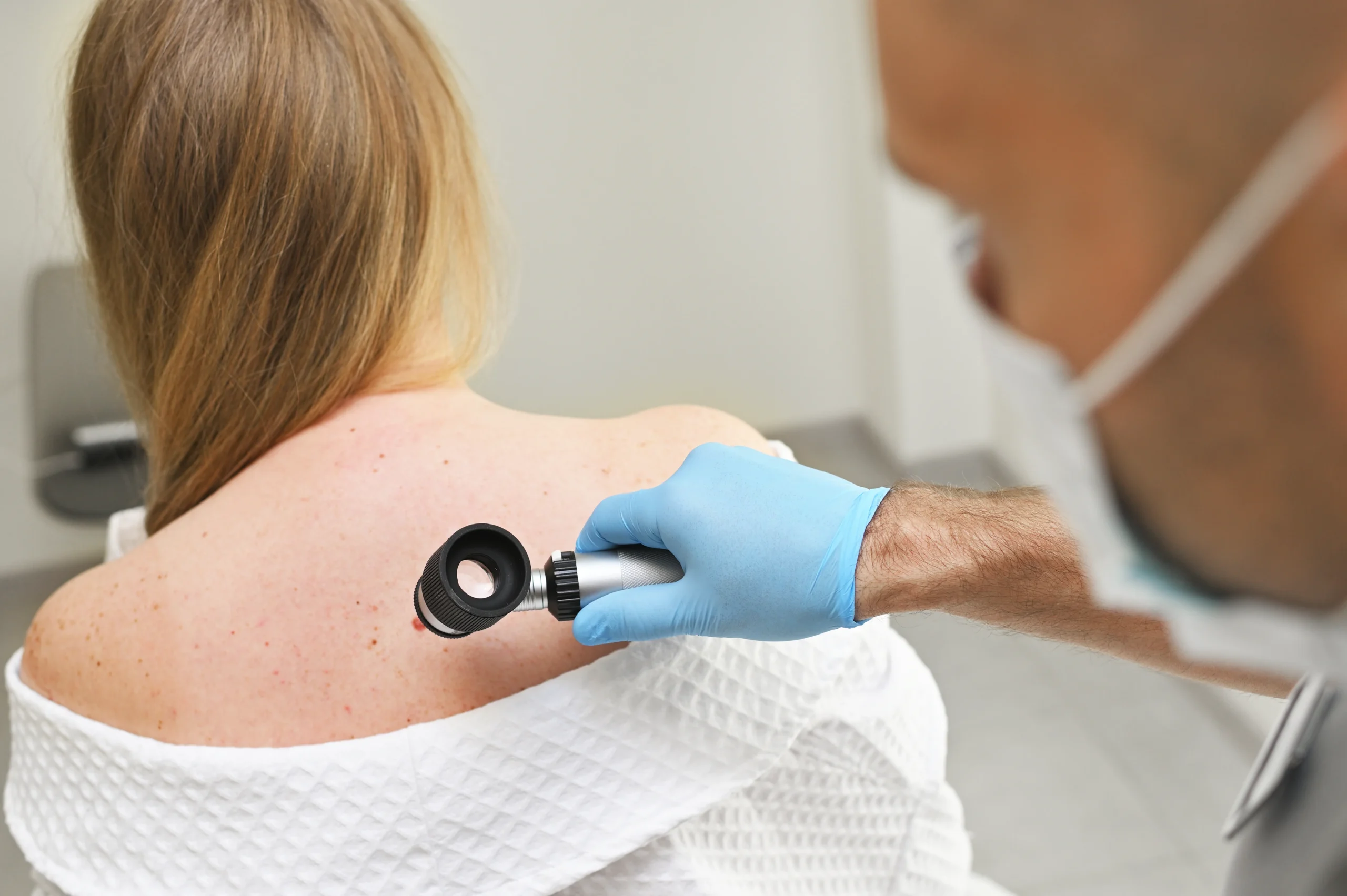 dermatologist-examines-woman-s-back-with-dermatosc-2026-09-23-06-47-01-utc dermatologist-examines-woman-s-back-with-dermatosc-